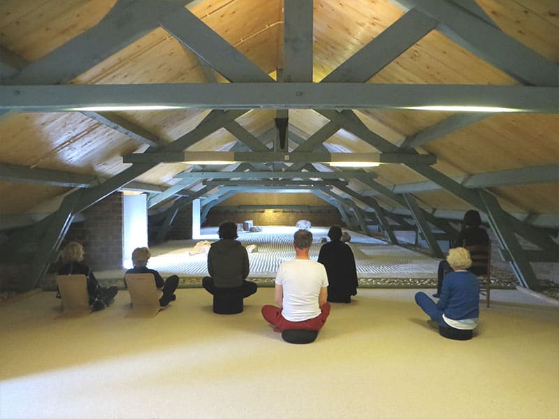 deelnemers van een mindfulness retraite in meditatieruimte